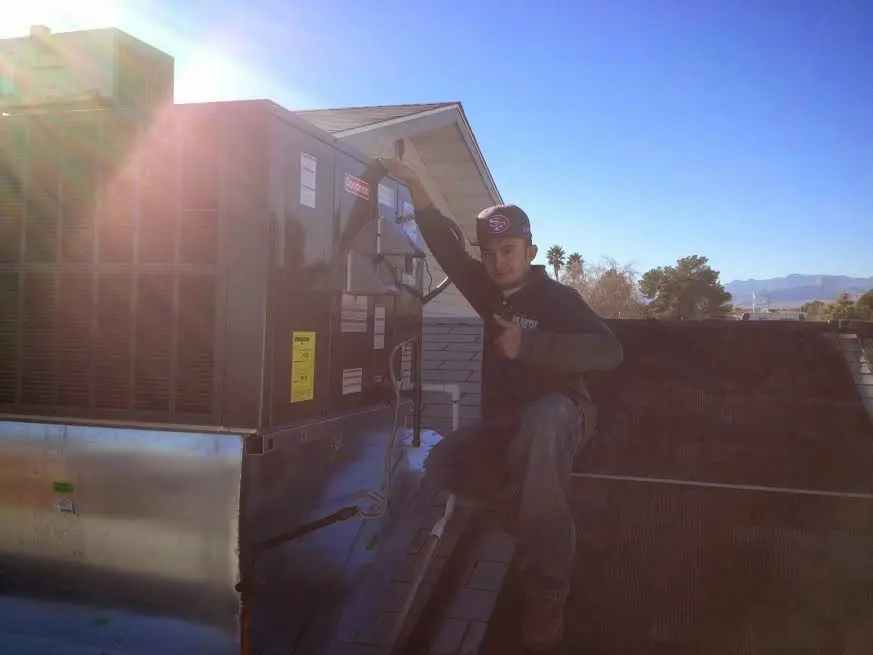 HVAC technician performing Boiler Repair on a rooftop unit in Jamestown